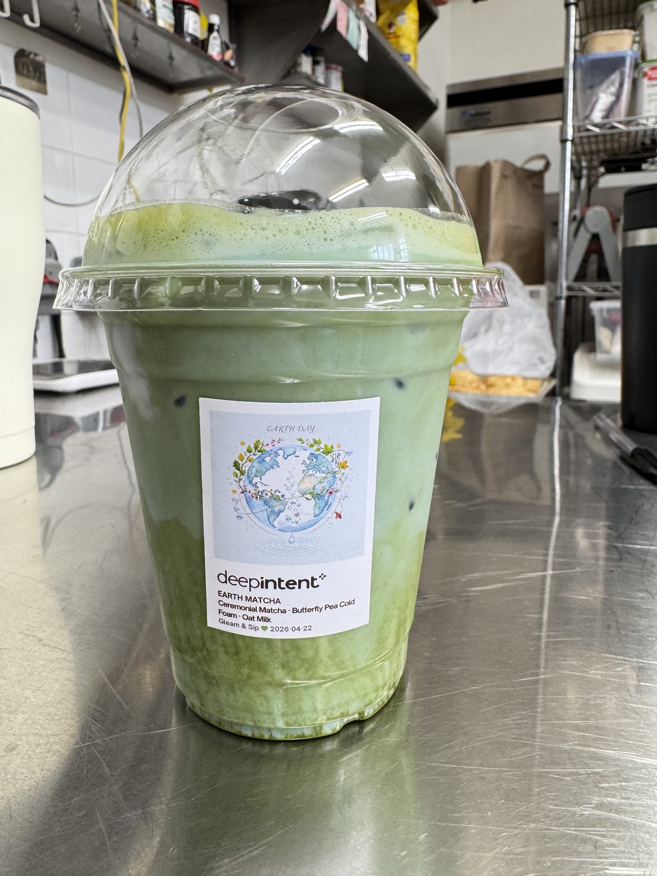 A finished iced matcha with a custom DeepIntent Earth Day label