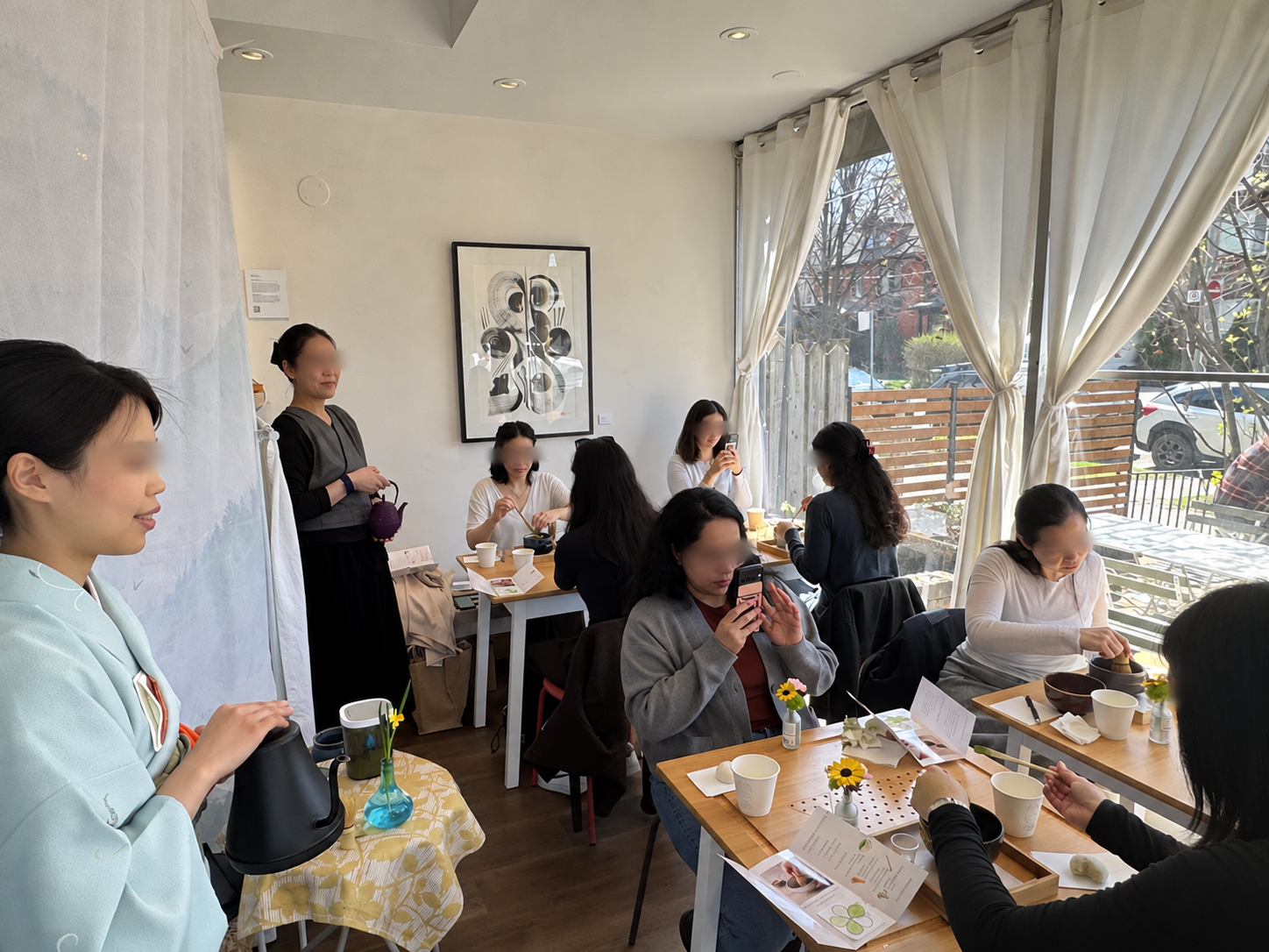 Guests sharing tea and whisking matcha during a cafe workshop